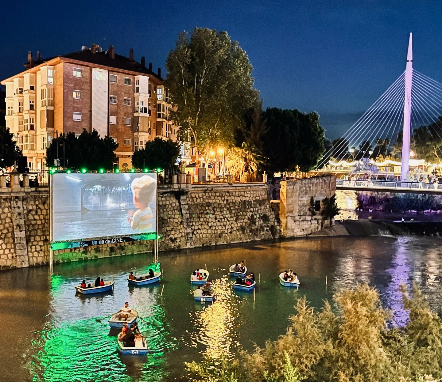 Barcas y público viendo una película junto al río Segura en Murcia