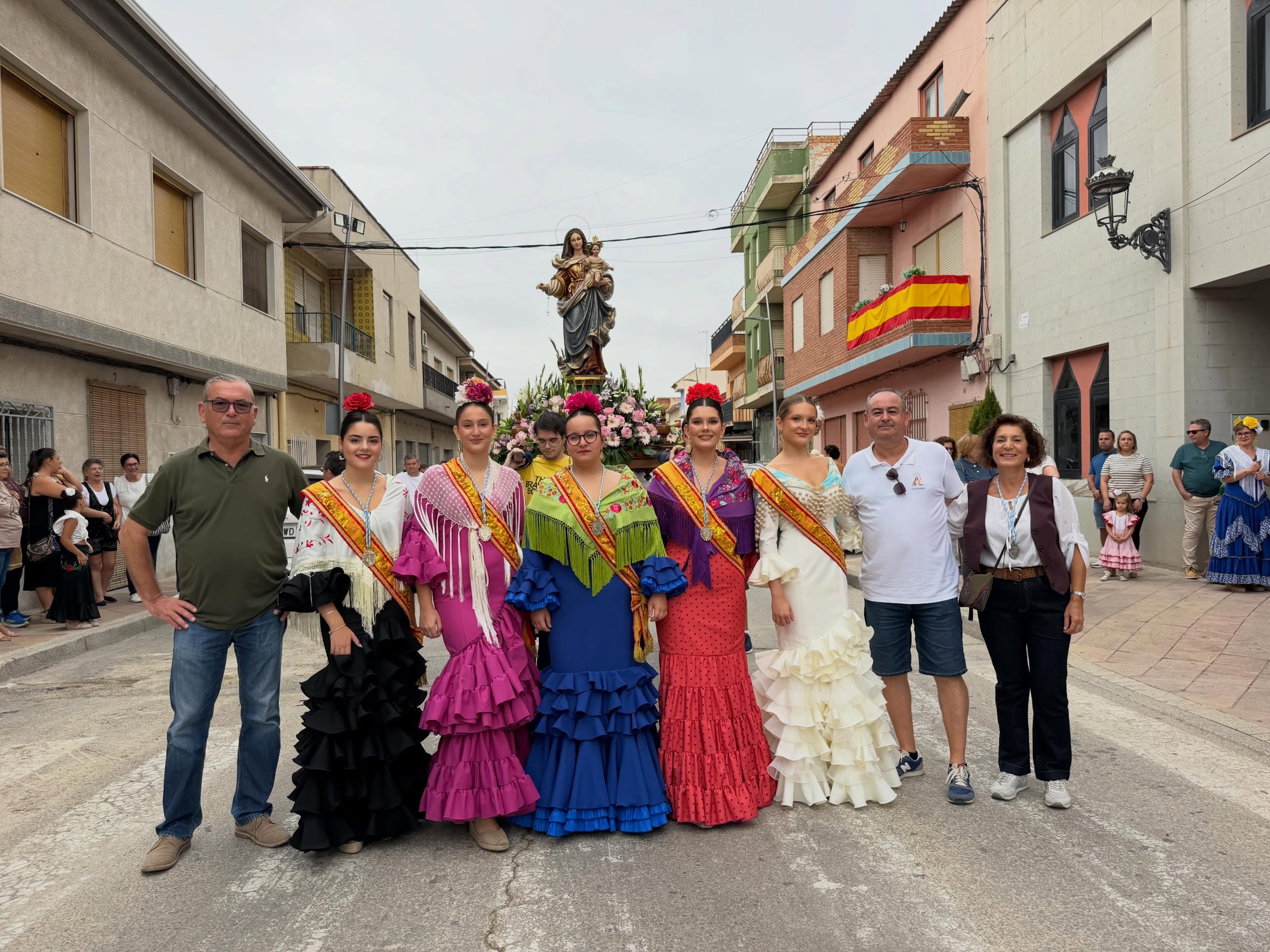 Participantes con trajes rocieros junto a la imagen de la Virgen del Rosario.
