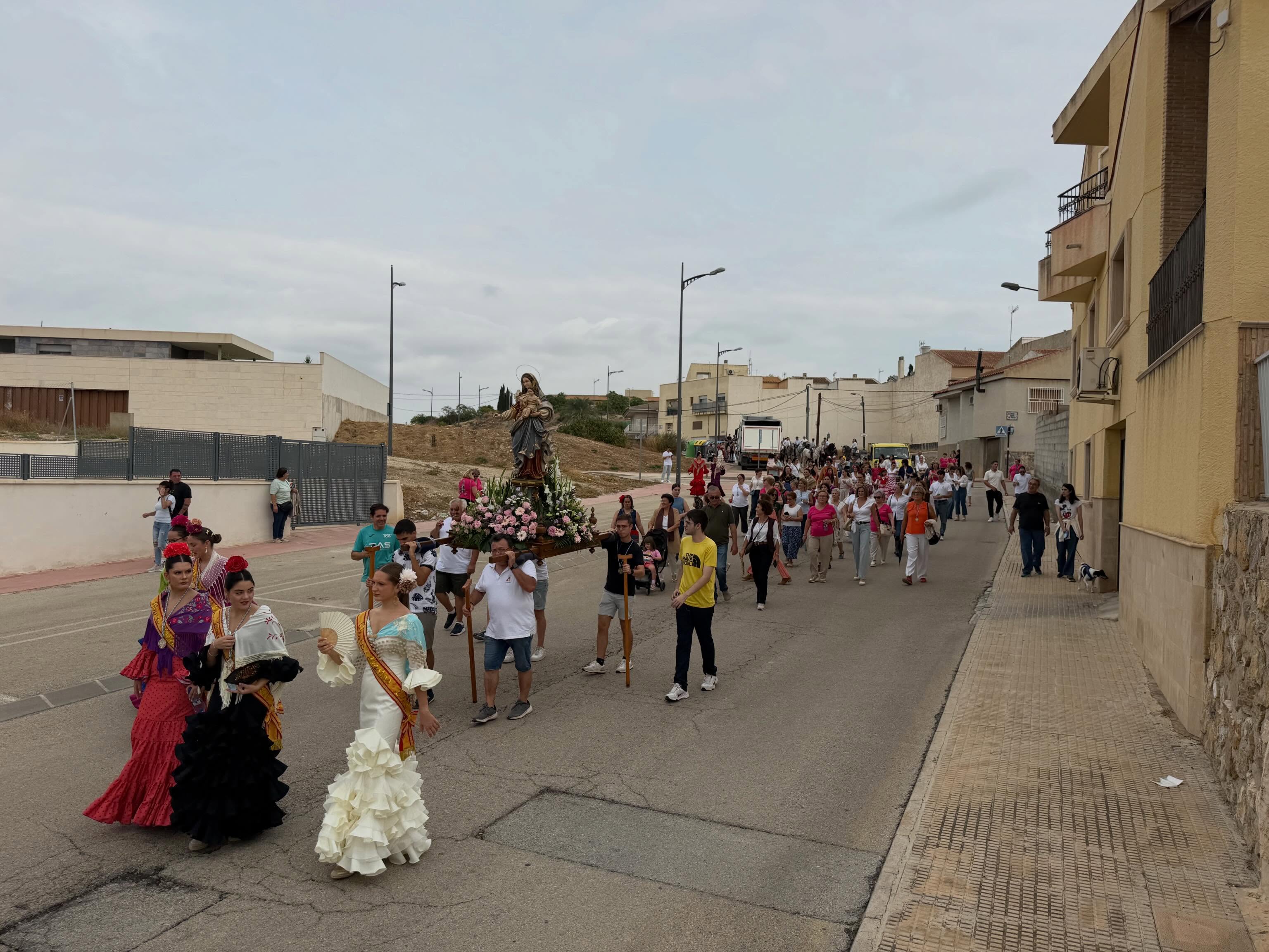 Vecinos acompañan las andas de la patrona durante la romería.